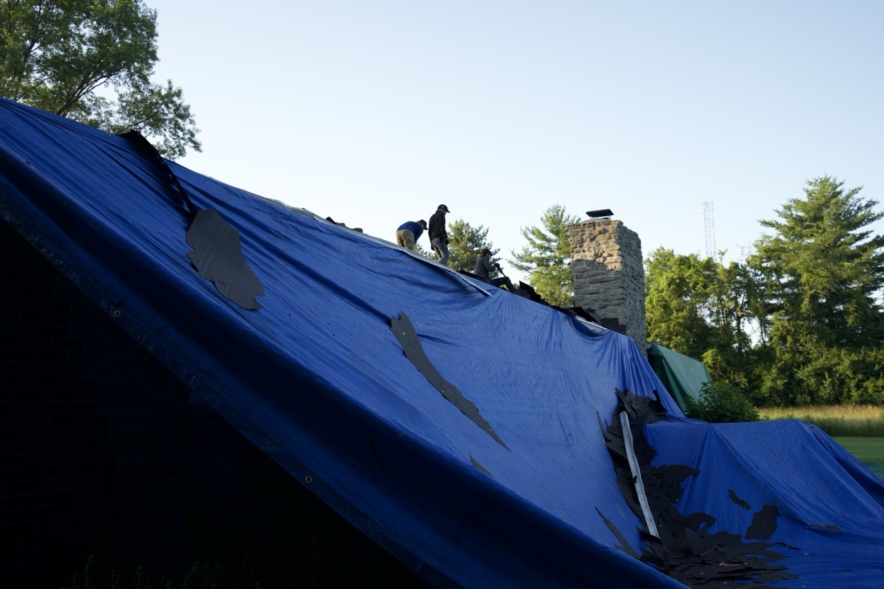 Roof tear-off at dusk by Liberty Township Roofing