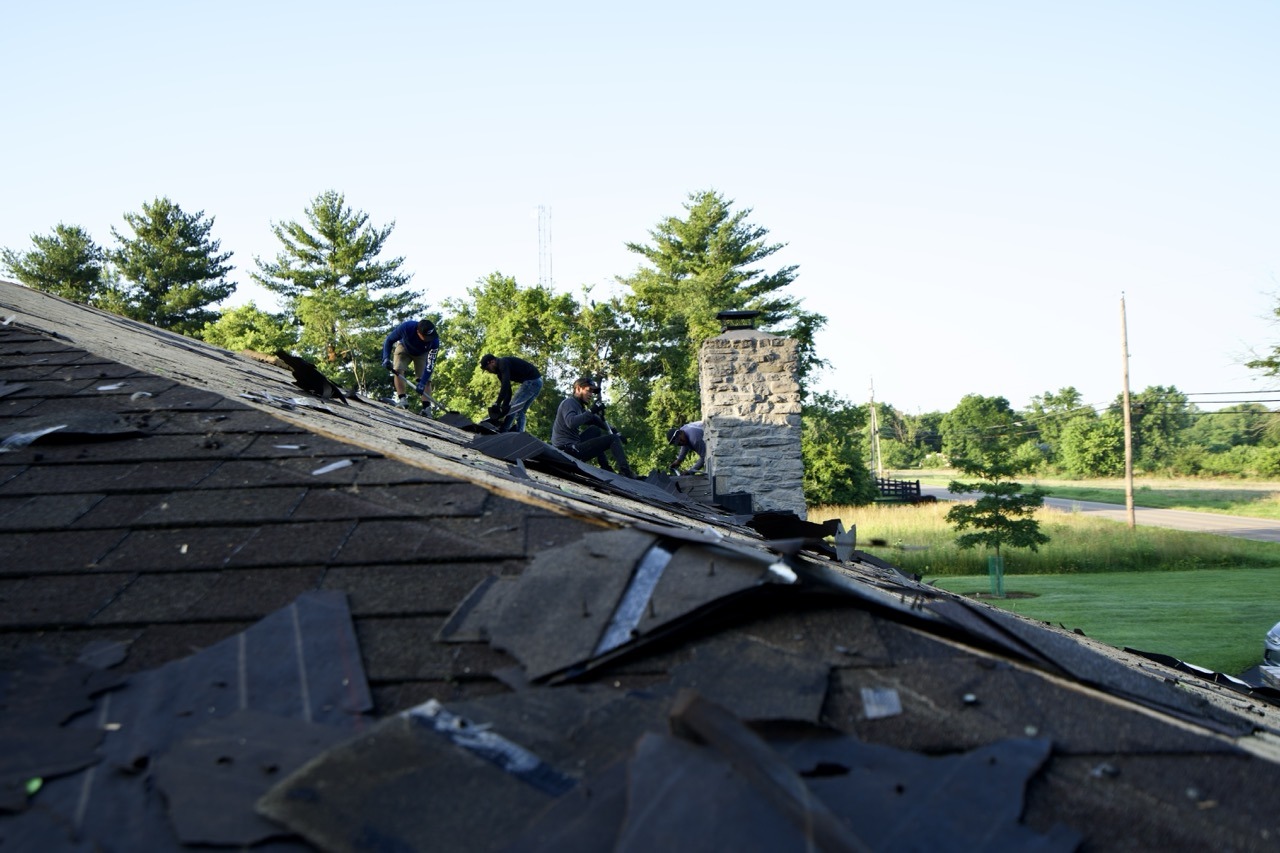 Liberty Township Roofing crew tearing off old shingles during a roof replacement