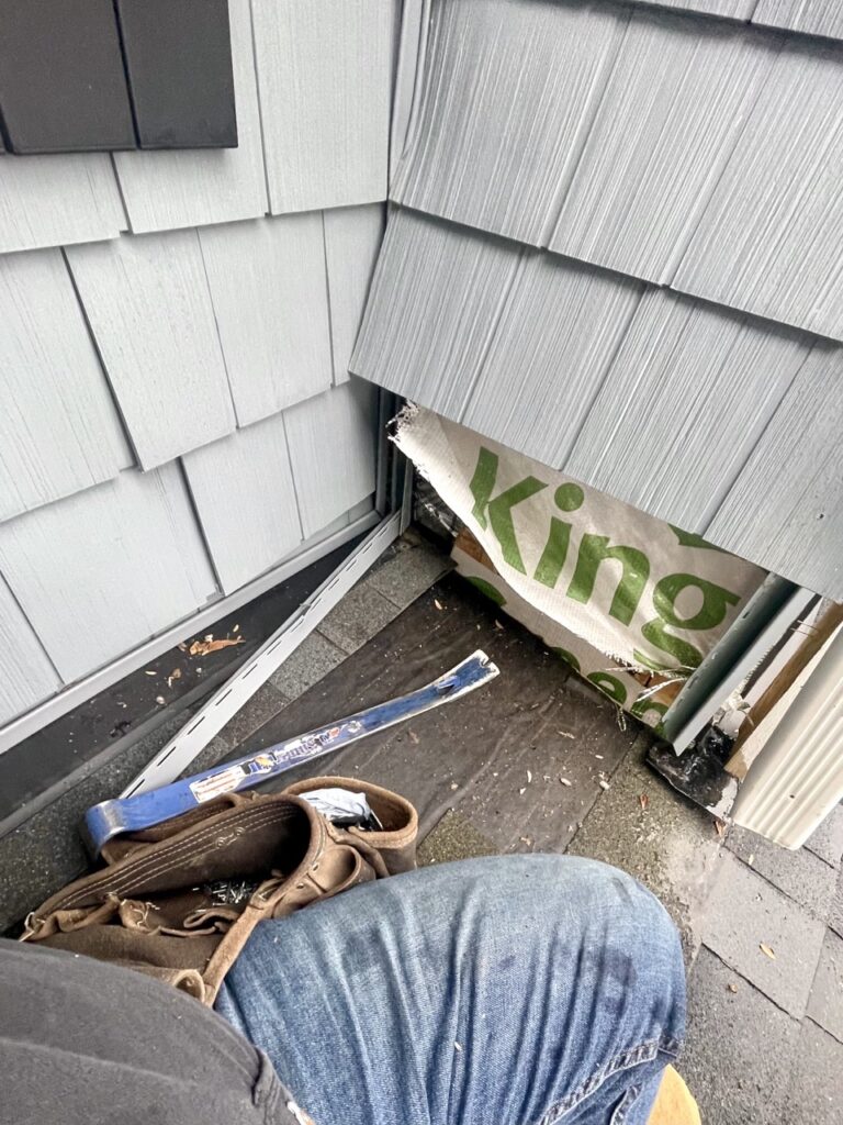 close up view of house siding removed for roof leak detection.